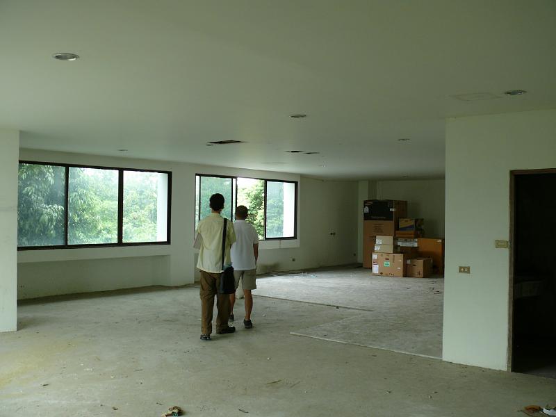 P1000053.JPG - A wider view of the unit's interior. The two tri-panel windows are against the south wall. These windows will be replaced during the construction project.

Where Chad and Jon are standing will be the guest room.

Jon's concept is to install moveable walls, promoting a sense of airy openness.