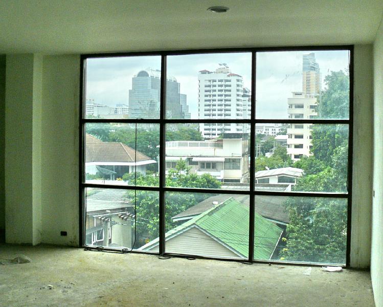 P1000065.JPG - One of the delights of this unit: the eastern window from another perspective. Another photo showed you the grove of trees.

This view makes Bangkok so special. Tall condos lead the eye into the horizon interleaved with conventional homes and greenery.

It's not visible from this angle, but a former finance minister owns a gated mansion just across the soil from this window.