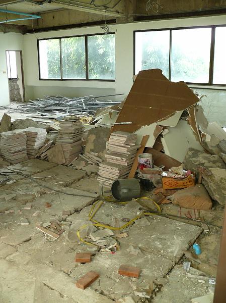 P1000243.JPG - All drop ceiling supports have been removed and piled by the guest area (upper left). Wall tiles and ceiling pieces fill the living room area. Remaining concrete tiles are being loosened.
