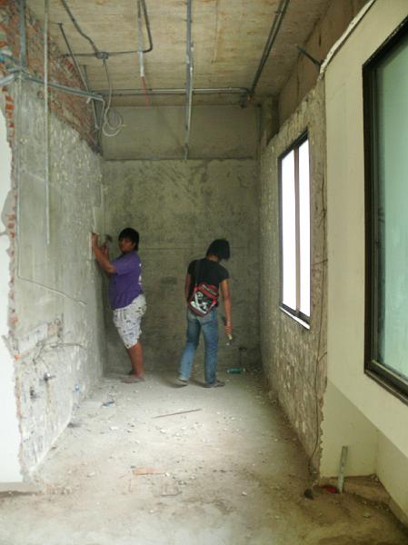 P1000278.JPG - Workers remove the vestiges of material from the guest bath wall.