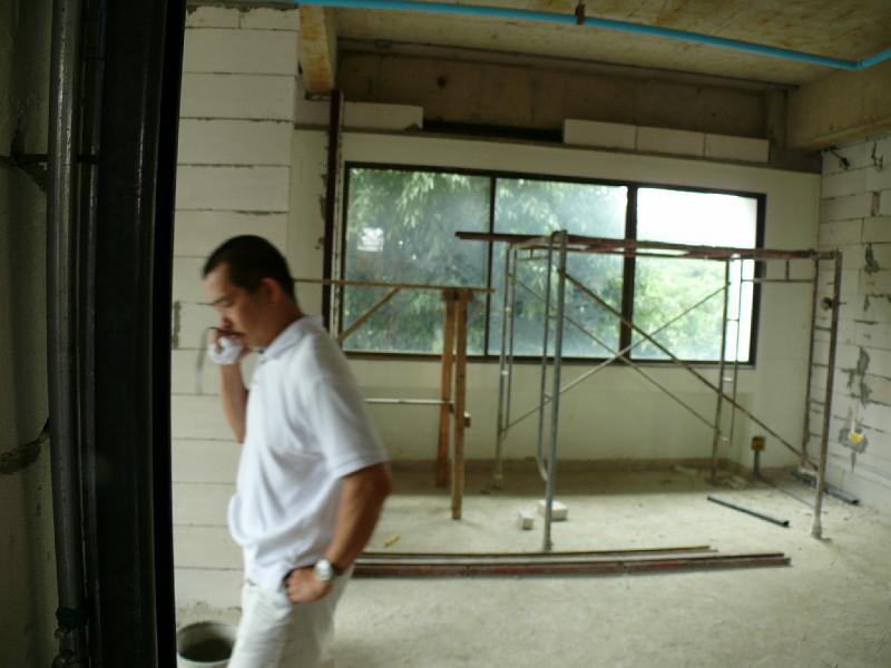P1000315.JPG - Jon confers with a contractor while standing in what will become my work area. (Background: guest bedroom)