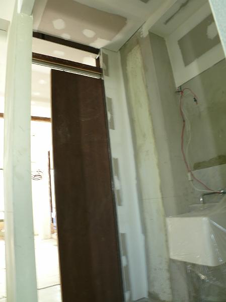 P1000699.JPG - The sliding door has been installed in the half bath entrance to the main hallway.
