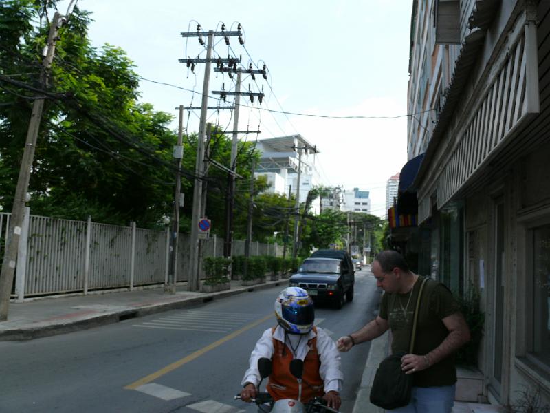 P1000110.JPG - At the corner of Soi 53 and Sukhumvit. A rider settles his fare with the motorcyclist.
